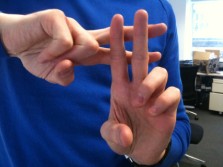 person forming a hashtag symbol with his index and middle finger of both hands